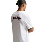 Person wearing a white t-shirt with 'ENGLAND' printed on the back, standing against a white background.