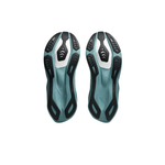 A pair of cycling shoes shown from the bottom, featuring a teal and black textured sole with white accents, set against a plain white background.