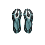 A pair of cycling shoes shown from the bottom, featuring a teal and black textured sole with white accents, set against a plain white background.