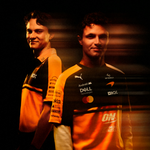 Two men wearing orange and black PUMA McLaren replica jerseys with various sponsor logos