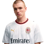 A male model wearing a white Puma AC Milan soccer jersey with the Emirates sponsor logo, featuring the club's crest on the chest.