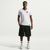 Person wearing a white sports jersey and black shorts on a white background