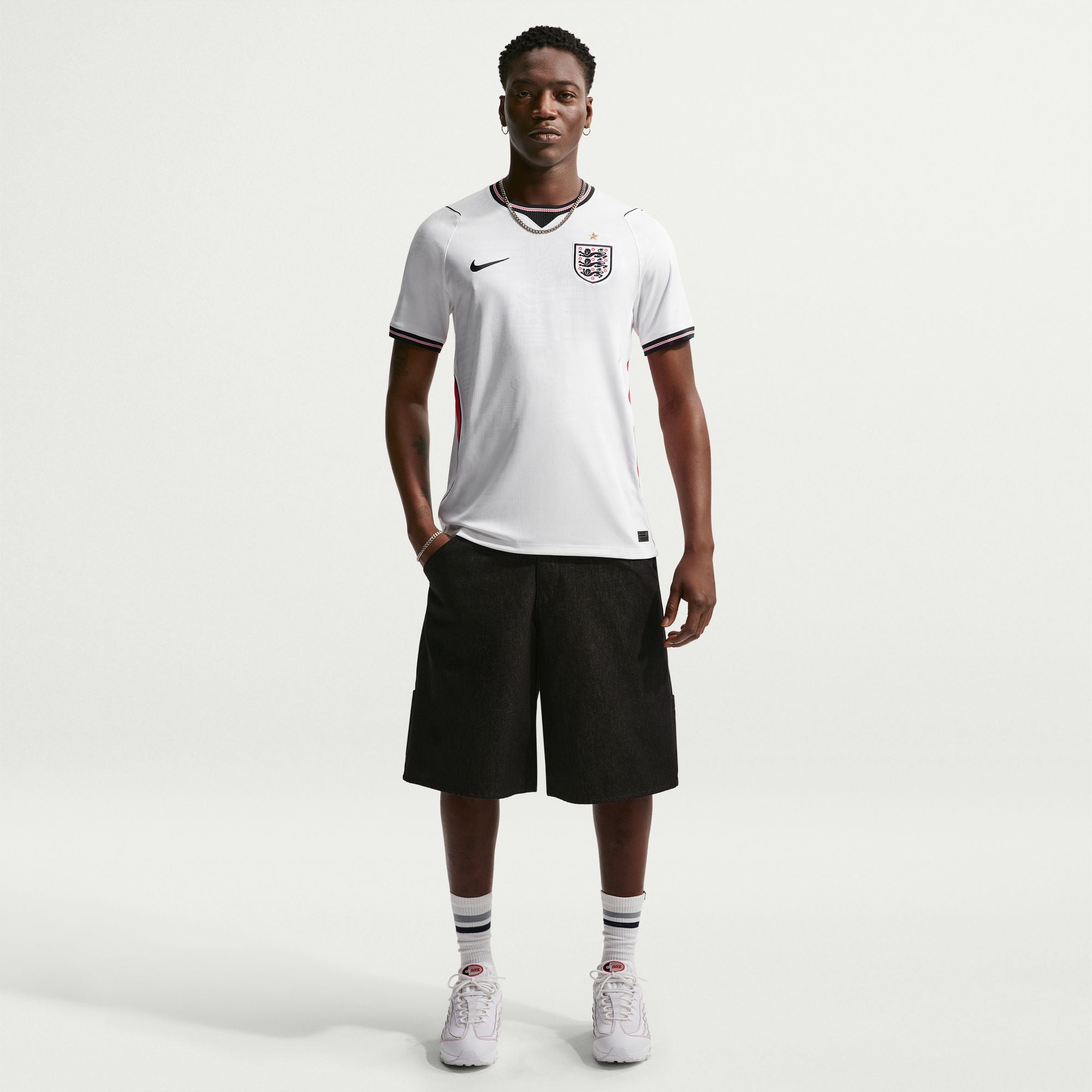 Person wearing a white sports jersey and black shorts on a white background