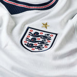 Close-up of a white sports jersey with a prominent emblem featuring lions and a star.