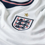 Close-up of a white sports jersey with a prominent emblem featuring lions and a star.