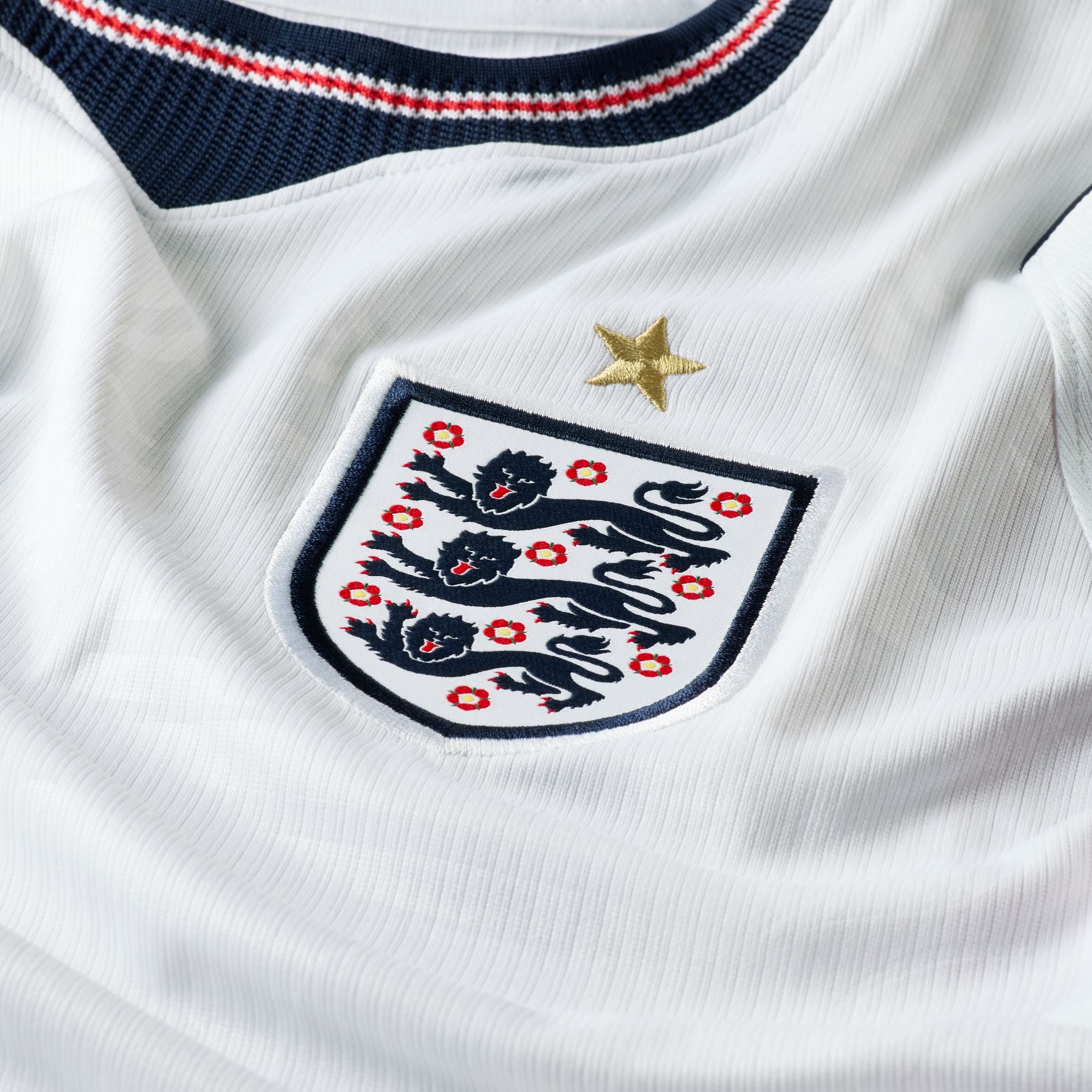 Close-up of a white sports jersey with a prominent emblem featuring lions and a star.
