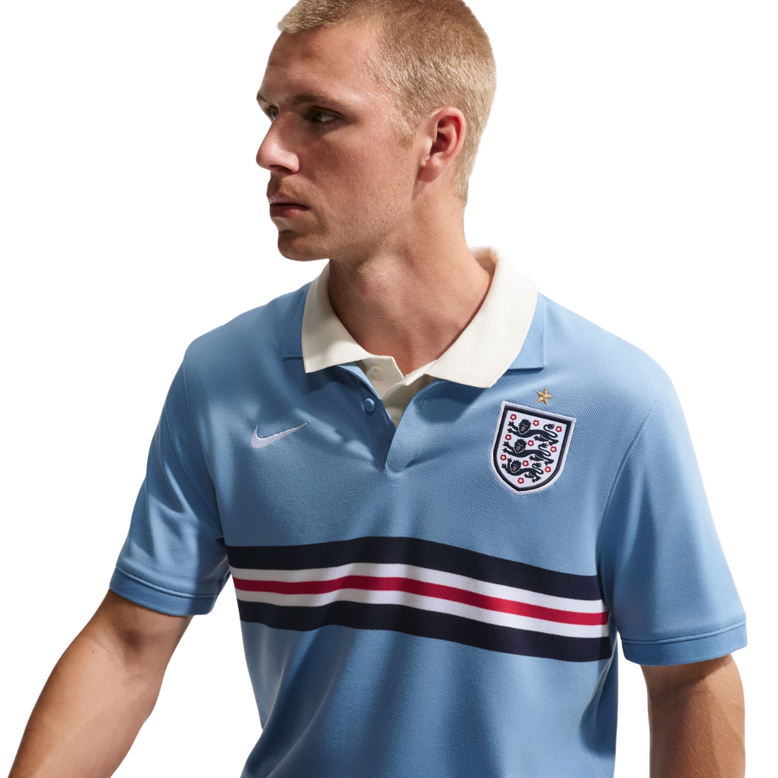 Man wearing a light blue polo shirt with a logo on a white background