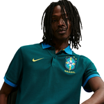 Person wearing a green sports jersey with a logo on a white background