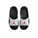 A pair of black and white slide sandals with red Jumpman logos on the straps, shown from a top-down view on a white background.