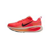 A Nike running shoe in a vibrant coral pink and orange gradient, featuring a black Swoosh logo and a white and orange ZoomX midsole, shown against a plain white background.