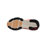 The outsole view of a Nike sneaker, showing a white and beige midsole with black rubber outsole, a red Nike Swoosh on the heel, and a red accent near the toe.