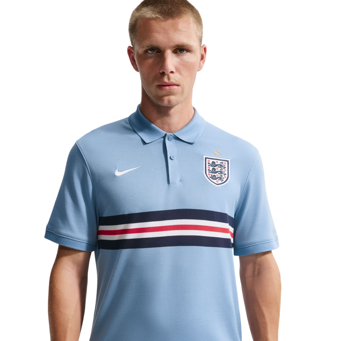 Man wearing a light blue polo shirt with Nike and England national team logos on a white background