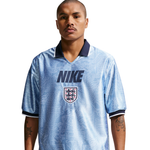 Person wearing a light blue soccer jersey with Nike logo and England national team emblem on a white background