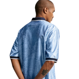 Person wearing a blue patterned shirt on a white background