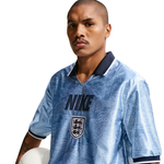 Person wearing a blue Nike soccer jersey with a white background