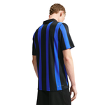A man wearing a short-sleeve athletic jersey with vertical black and royal blue stripes, shown from the back against a plain white background.