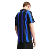 A man wearing a short-sleeve athletic jersey with vertical black and royal blue stripes, shown from the back against a plain white background.