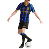 A soccer player wearing a black and blue striped Inter Milan jersey with 'betsson sport' sponsor logo, black shorts, and black socks, balancing on a white soccer ball against a white background.