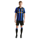 A male model wearing a black and blue vertically striped Inter Milan soccer jersey with 'betsson SPORT' sponsor logo, black shorts, and black socks with blue accents, on a plain white background.