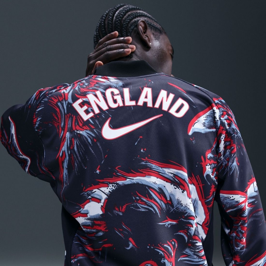 Person wearing a sports jersey with 'England' and Nike logo on a dark background