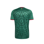 Green short-sleeve athletic t-shirt with a large black Aztec calendar pattern on the back and red trim on the collar and sleeve cuffs, shown against a plain white background.