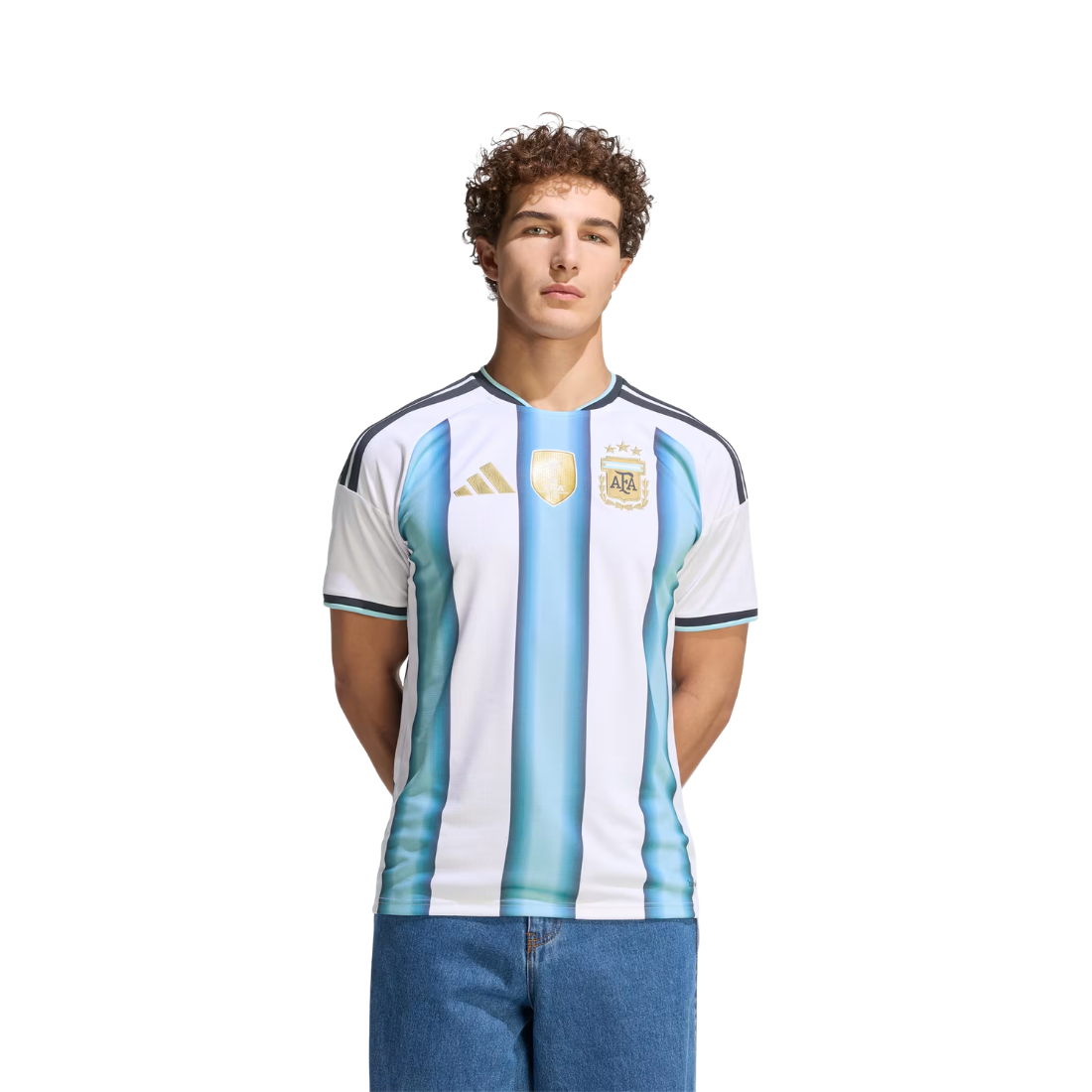 A young man modeling an Argentina national football team home jersey by Adidas. The jersey features the classic light blue and white vertical stripes with dark blue shoulder stripes and gold crests.