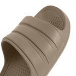 A close-up of a single taupe-colored slide sandal, showing the textured footbed and three horizontal strap details against a clean white background.