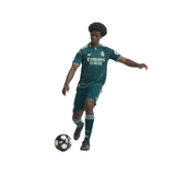 A soccer player in a dark green Real Madrid kit with white accents, including the Emirates Fly Better sponsor logo, is captured mid-action kicking a black and white soccer ball against a solid white background.