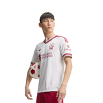 A young male soccer player wearing a white and red Liverpool FC jersey, holding a soccer ball against a solid white background.