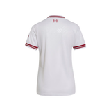 White short-sleeve soccer jersey shown from the back, featuring red stripes on the collar and sleeve cuffs, and a red crest at the top center.
