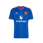 A blue short-sleeve soccer jersey with red and white trim on the collar and sleeves, featuring the Adidas logo on the right chest, the Manchester United crest on the left chest, and the Snapdragon sponsor logo across the center.