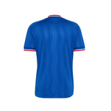 A blue short-sleeve athletic jersey shown from the back, featuring a subtle vertical wavy texture and red and white trim at the collar and sleeve cuffs, set against a plain white background.