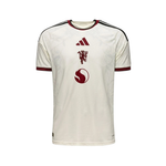 An Adidas Manchester United home soccer jersey in off-white with dark red and black accents, featuring the club's crest and Adidas logo on the front.
