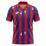 A short-sleeve polo soccer jersey with vertical red and blue stripes, featuring white geometric diamond logos on the chest and shoulders, and a white diamond logo on the right chest. The collar has red and white trim.